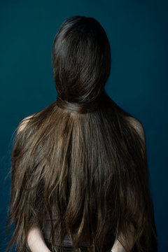 Portrait of a woman with her face covered in hair.