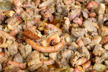 Different types of deep fried meat pieces and sausages, in display for sale at an weekend street food market