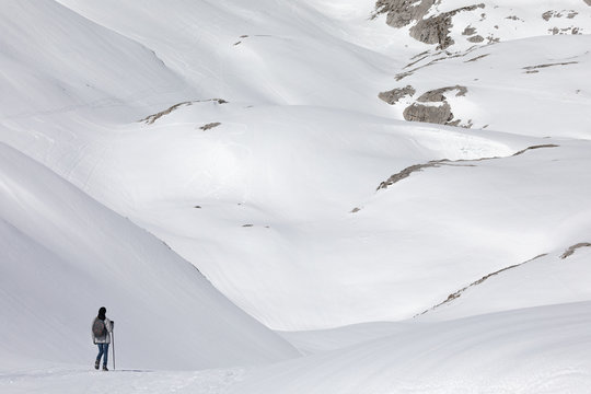 Lone woman trekking in snowy mountains