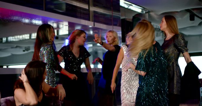 female friends are having fun in nightclub, dancing together, bachelorette party