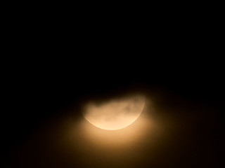Part of the moon behind the clouds