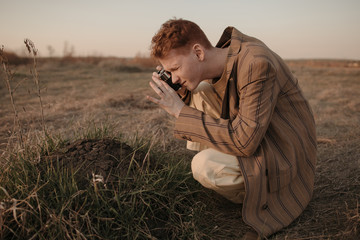 Young man taking picture of dirt pile