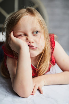 Child leaning on her hand looking bored