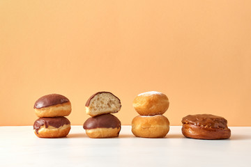 Homemade fresh donuts and buns on a duotone beige light background.