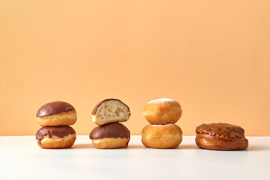 Homemade fresh donuts and buns on a duotone beige light background.