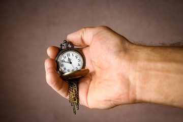 a pocket watch in the hands of a man
