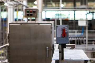 on and off industrial red switch in on position selective focus, packaging machine, belt conveyor...