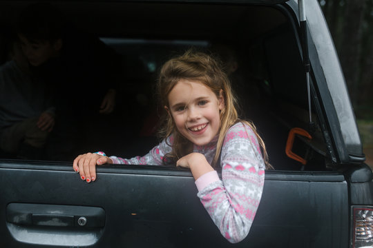 girl smiling in the back of a pick up truck