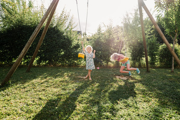 stock photo fo little girls on a swing in the backyard