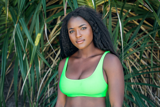 African woman in swimsuit lookin at camera