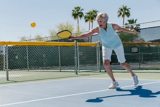 Senior Woman Playing Pickleball on Court