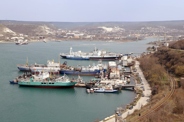 Fototapeta premium Top view on beginning of Sevastopol bay with many ships and docks. Railway is at right of picture. Day is sunny.