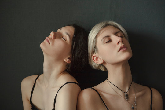 portrait of blondes and brunettes together on a neutral background with closed eyes