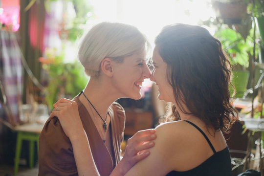 two girls lesbians laugh and look into each other's eyes with a soft light