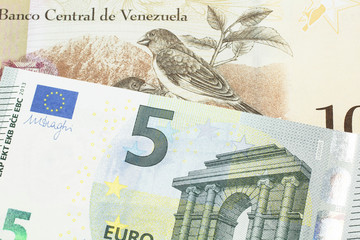A one hundred Bolivar note from Venezuela with a five Euro note from the European Union eurozone...