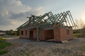 Fototapeta na wymiar Dom w trakcie budowy z drewnianą więźbą dachową