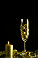 Christmas New Year holiday glass of champagne wine tangerines golden candle fire Christmas toys dark black background