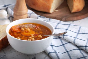 Soup with chicken, peas, tomato and sliced carrots. Tasty hot soup.