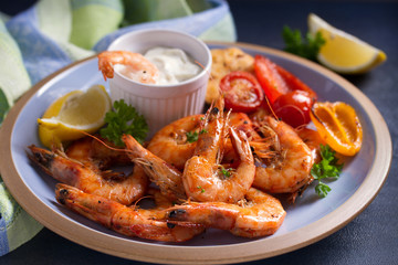 Shrimps with sauce, lemon and vegetables. Seafood