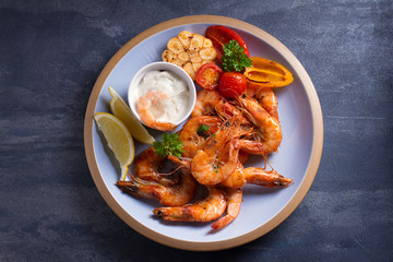 Shrimps with sauce, lemon and vegetables. Seafood. View from above, top