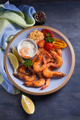 Shrimps with sauce, lemon and vegetables. Seafood. View from above, top