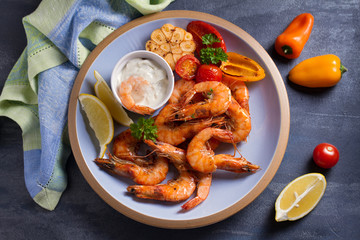 Shrimps with sauce, lemon and vegetables. Seafood. View from above, top