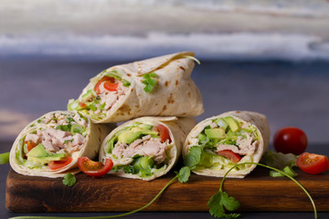 Chicken wraps with avocado, tomatoes and iceberg lettuce. Tortilla, burritos, sandwiches, twisted...