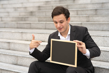 Businessman sit at office staircase.
