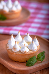 Elegant cupcakes with lemon Kurd and meringue scorched by a flame. Very tasty cupcakes. Tartlet filled with lemon cream (Kurd) and meringue