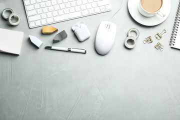 Flat lay composition with wired computer mouse and stationery on light grey table. Space for text