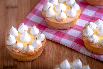 Obraz na płótnie Canvas Elegant cupcakes with lemon Kurd and meringue scorched by a flame. Very tasty cupcakes. Tartlet filled with lemon cream (Kurd) and meringue
