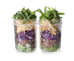 Glass jars with healthy meal isolated on white