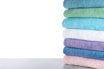 Fresh towels on light grey table against white background. Space for text