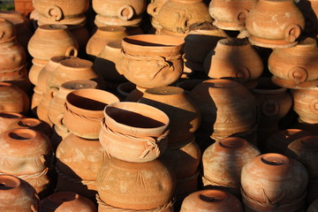 Fototapeta na wymiar open air workshop of ceramics, earthenware, orange and brown terracotta flower pots