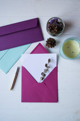 The pink envelope with note blank on the white wooden table. Beautiful desktop. Background with place for text.