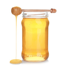 Jar of organic honey and dipper isolated on white
