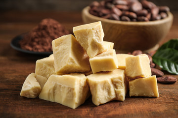 Organic cocoa butter on wooden table, closeup