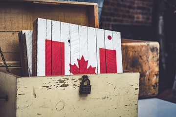 The Canadian flag painted in a piece of wood