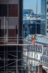Construction worker on scaffold on a building site in London, UK