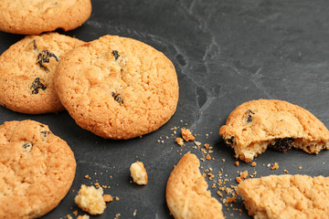 Delicious cookies with raisins on black table, closeup