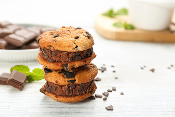 Sweet delicious ice cream cookie sandwiches on white wooden table. Space for text