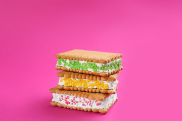 Sweet delicious ice cream cookie sandwiches on pink background
