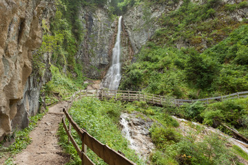 small waterfall among the forest in Val Gardena