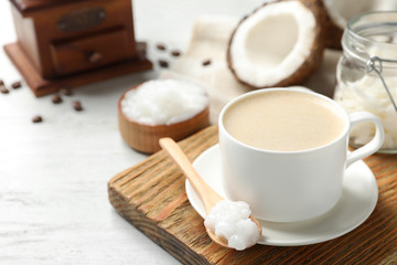 Delicious coffee with organic coconut oil on white wooden table