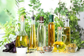 Different sorts of cooking oil in bottles and ingredients on light table