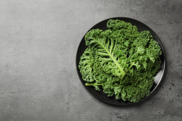 Fresh kale leaves on grey table, top view. Space for text