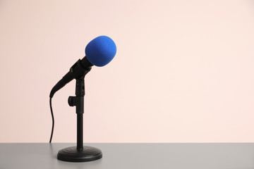 Microphone on light grey table, space for text. Journalist's work