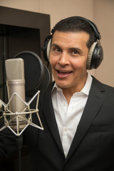 actor and radio announcer with headphones and microphone working film dubbing, performing radio...