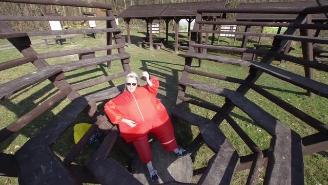 woman in a red outfit plays gitare in the middle of the forest