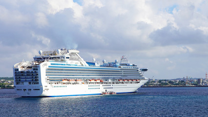 huge majestic white cruise liner in the clear blue turquoise water of the Pacific Ocean in the rays of the setting sun. vacation on tropical cruises